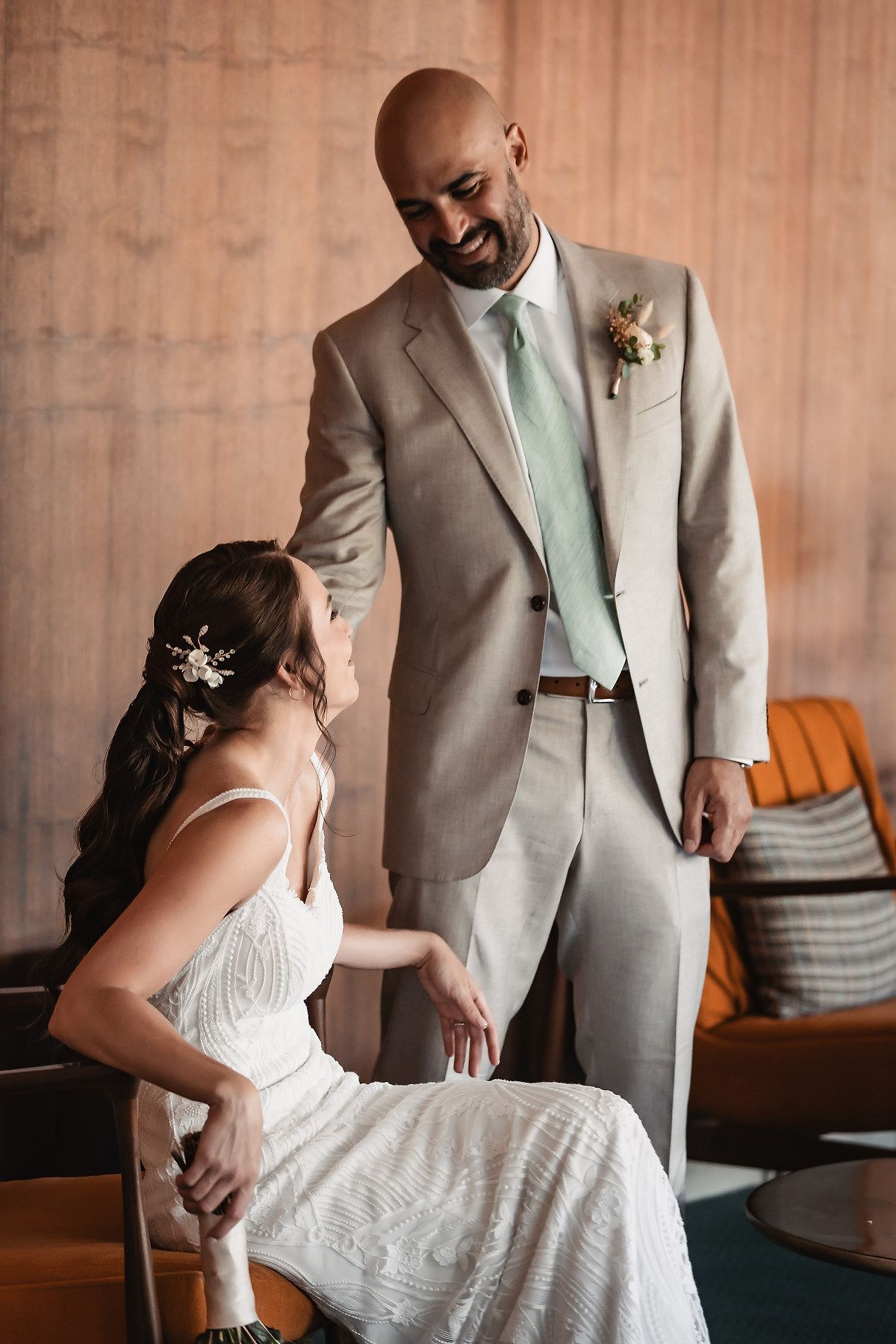 A couple shares an intimate dance moment in a room with warm lighting and wooden walls.