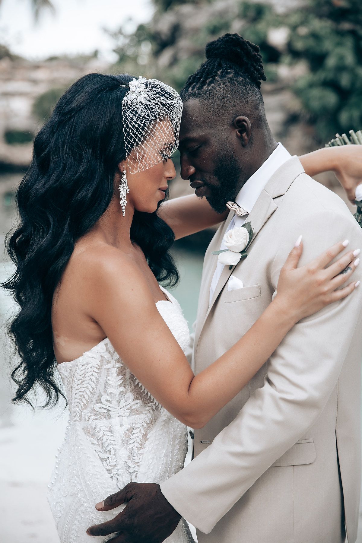 Intimate wedding portrait moment captured against a scenic coastal background.