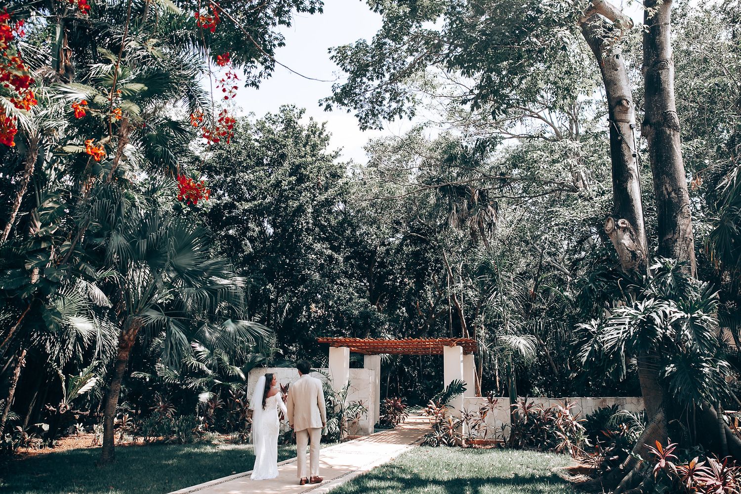 Wide panoramic view of a garden wedding venue with trees and decorative elements.