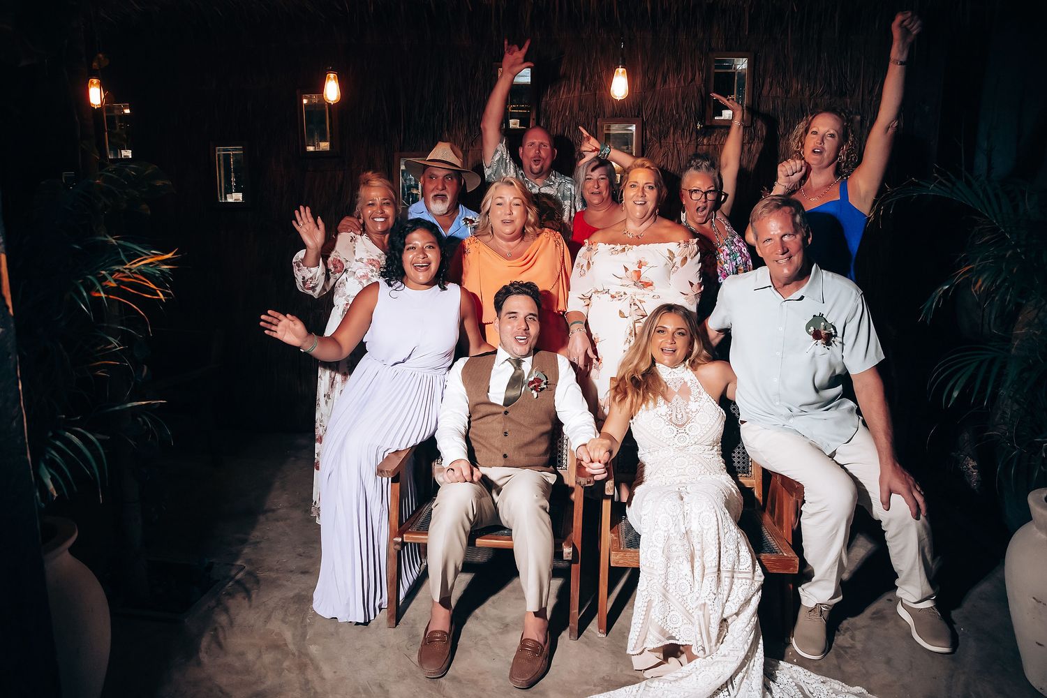Wedding guests dancing and celebrating at a beachside reception.