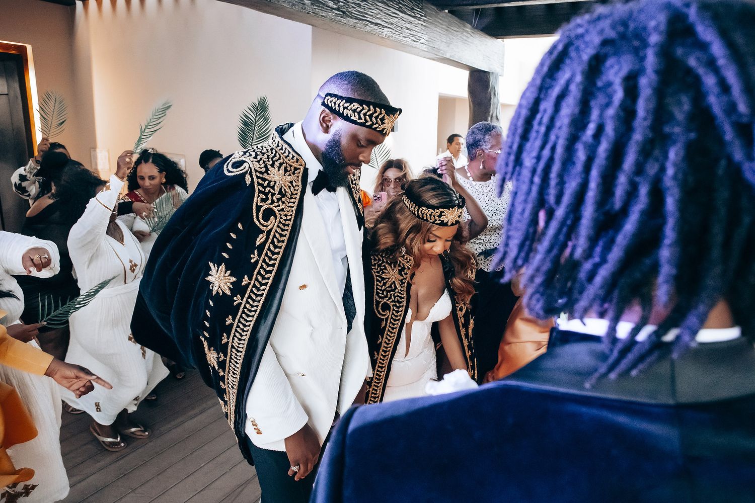 Wedding reception party scene with guests dancing and celebrating in a modern indoor venue.
