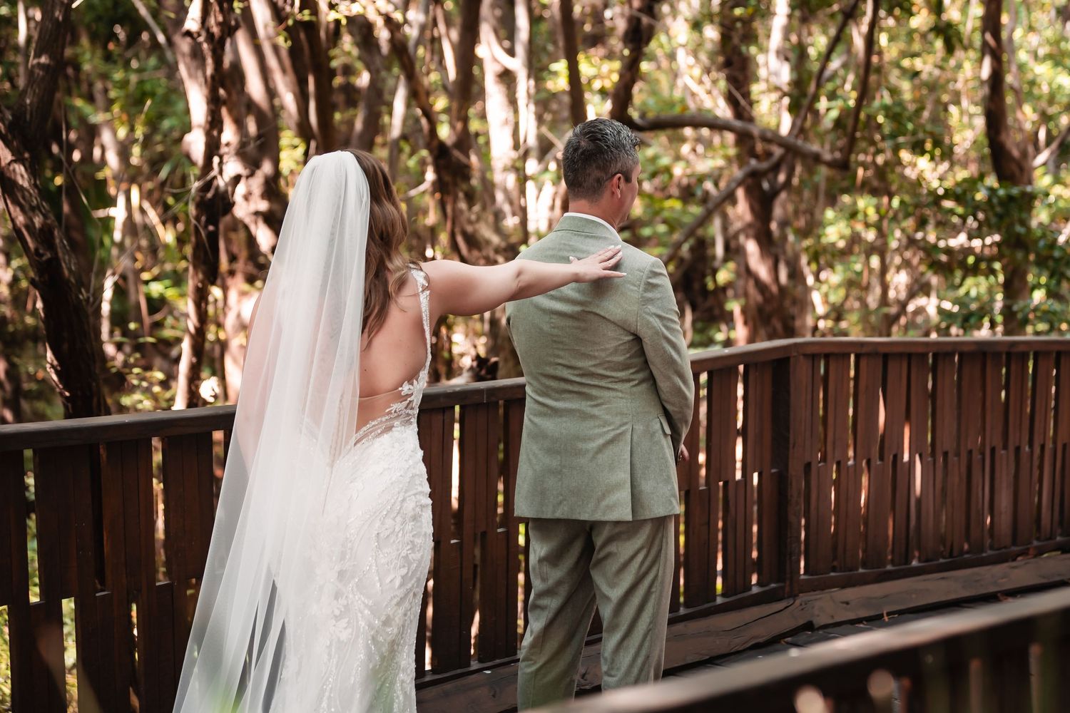A wooden boardwalk surrounded by tropical foliage provides an intimate wedding venue.