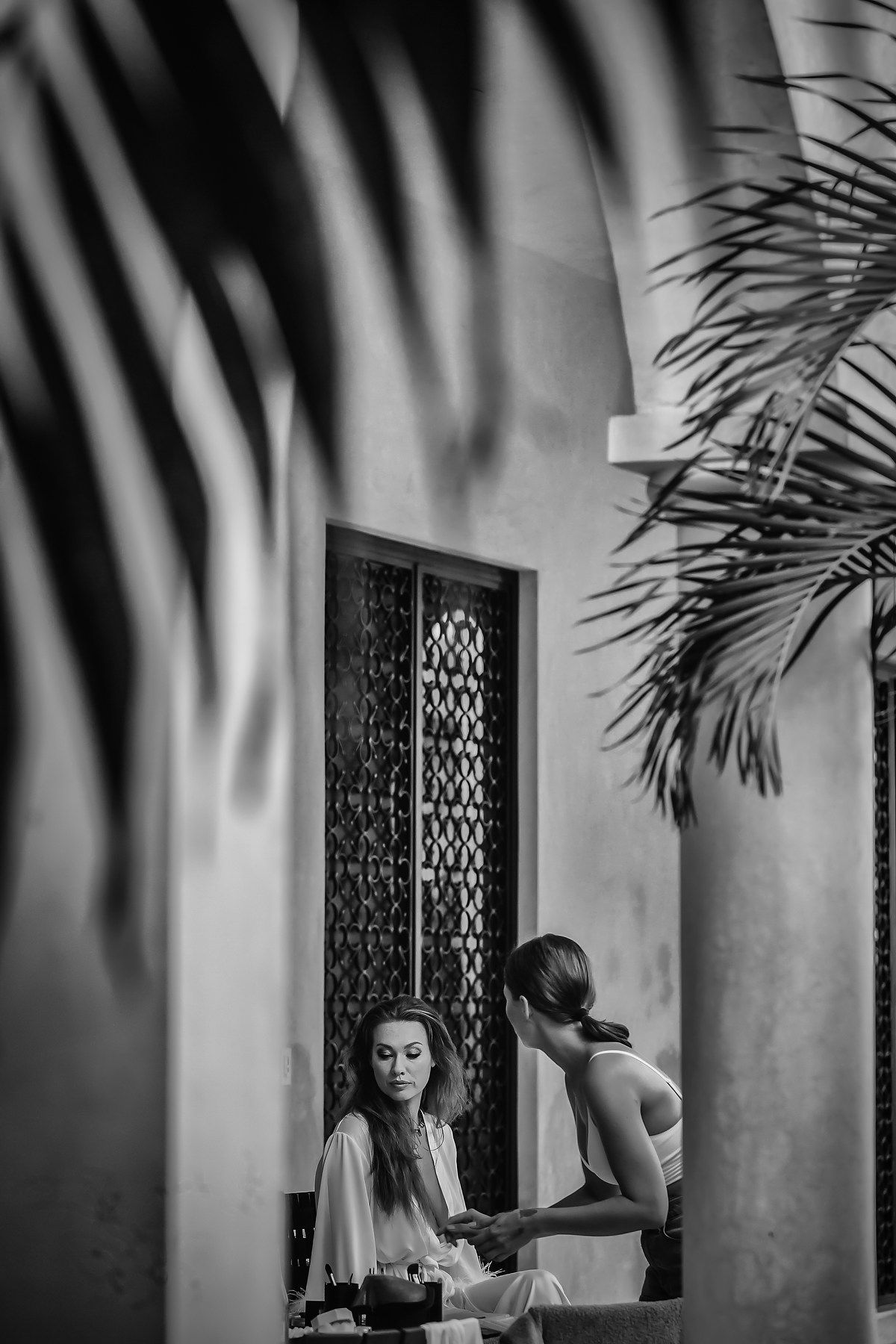 Black and white artistic bridal preparation photos with dramatic palm shadow patterns.