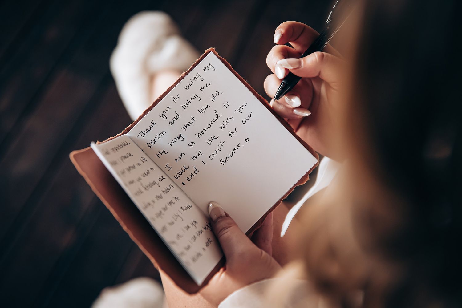 Close-up view of handwritten love letter or vows in a journal.
