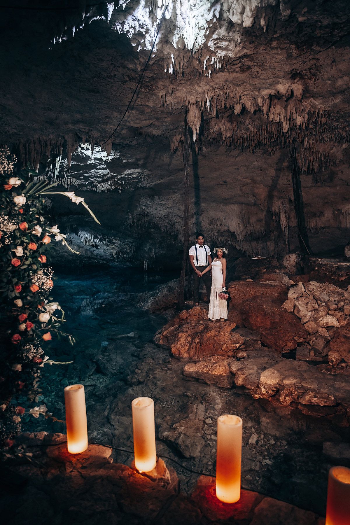 Glowing luminaries cast warm light against dramatic cave formations in a mystical underground setting.