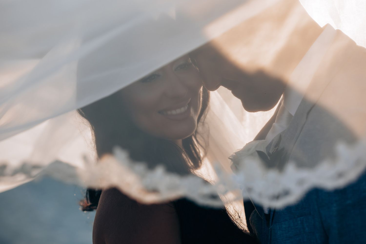 Soft focus wedding photography with flowing white fabric in natural light.