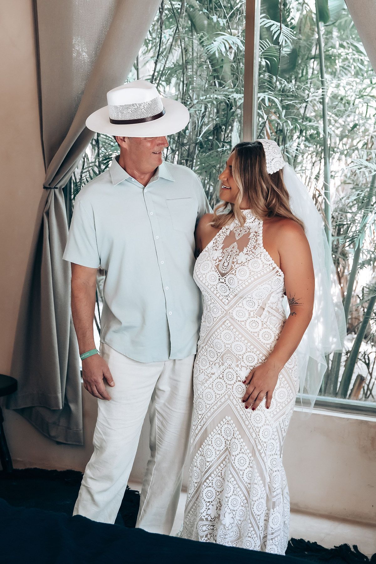 A couple in coordinating white outfits share tender moments in a series of romantic wedding photos.