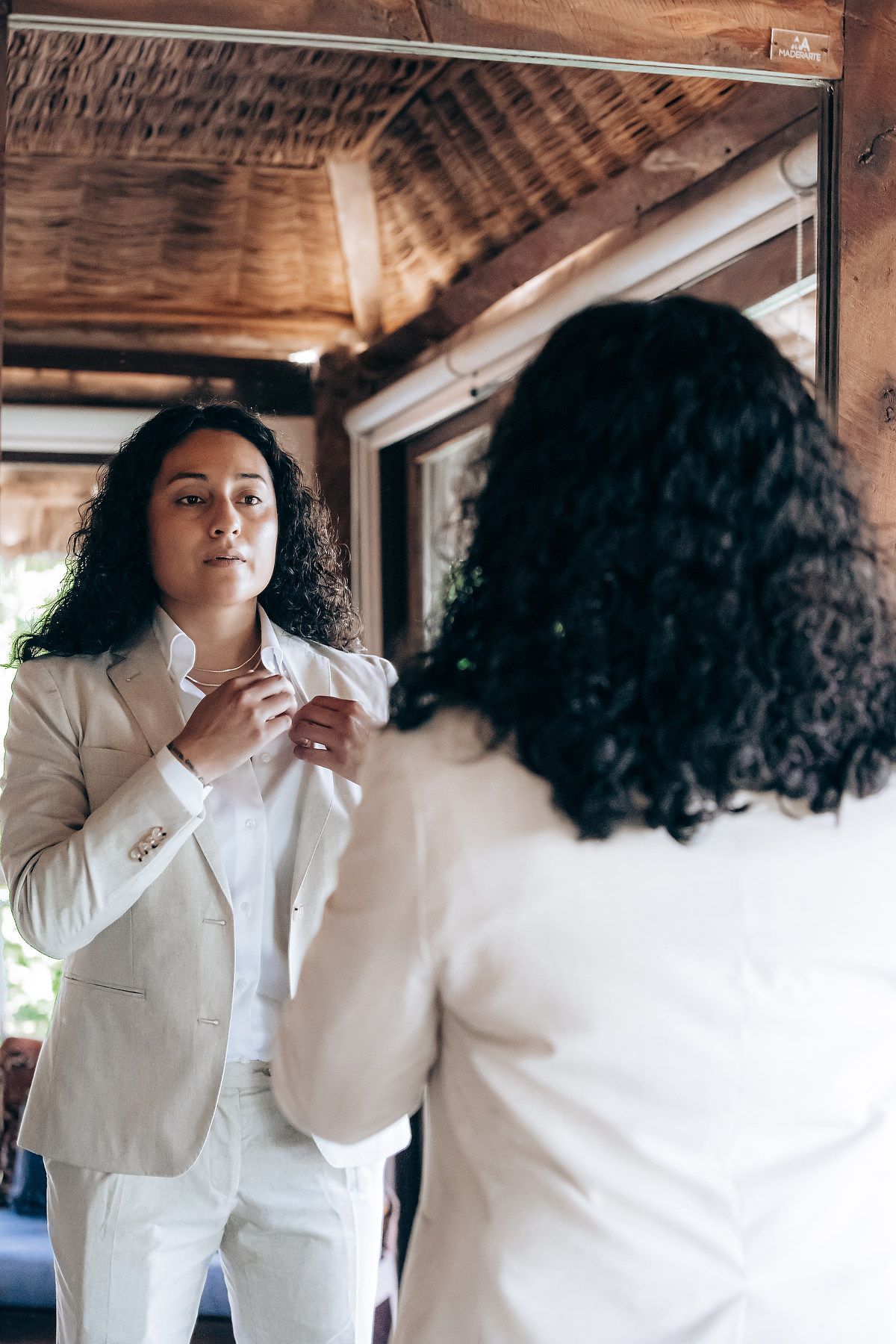 A series of photos showing someone in a white button-down shirt with curly hair against a rustic wooden wall.