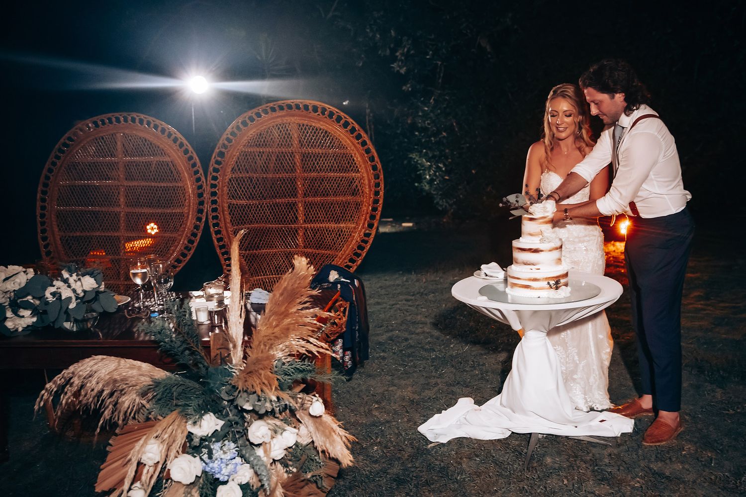 Wedding reception details with rustic wine barrels and romantic lighting at night.