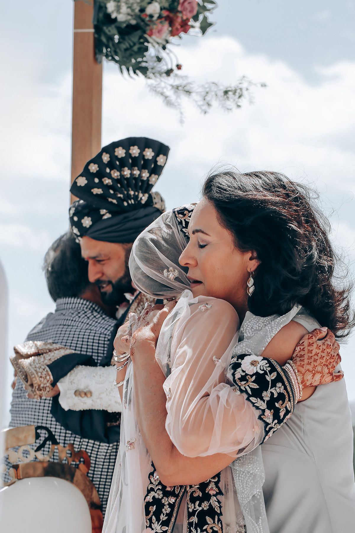 Romantic winter wedding couple sharing an intimate moment with snowy backdrop and embellished headpiece details.
