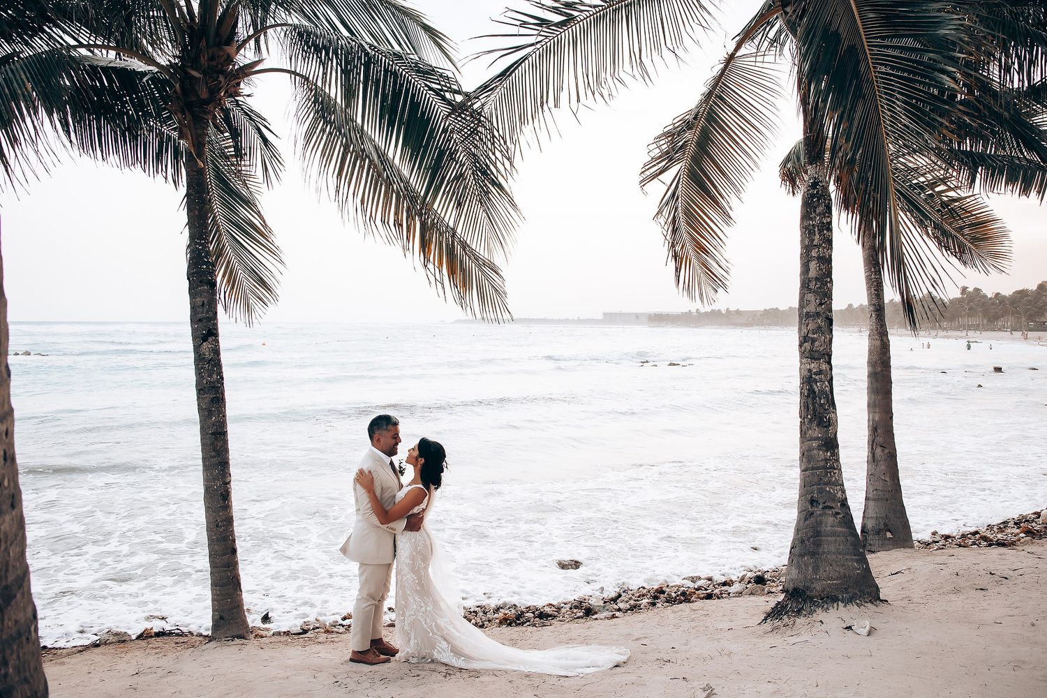 Bride and groom walking on the beach at Barcelo Maya Palace