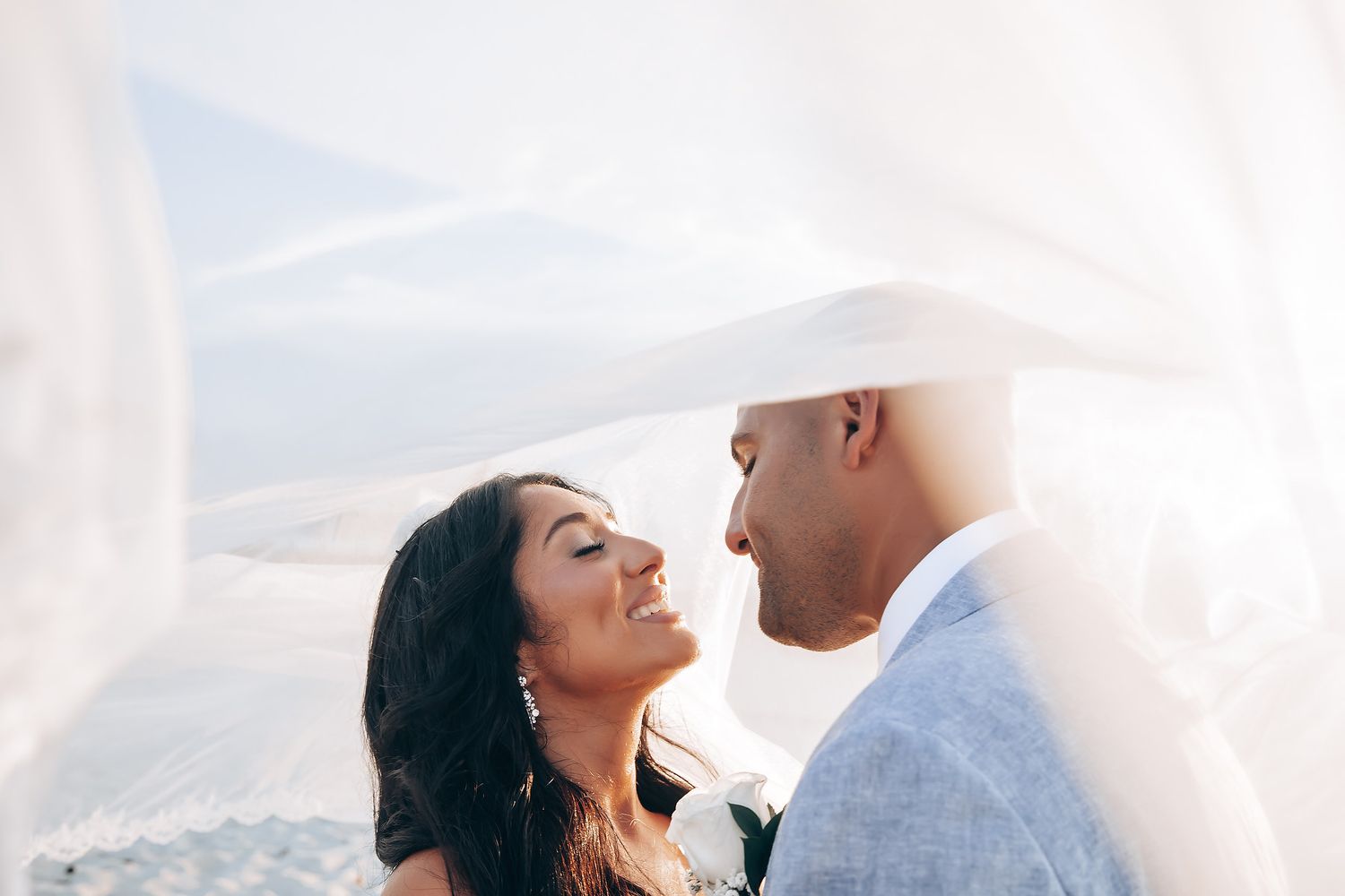 Romantic sunset wedding portrait with couple sharing intimate moment.
