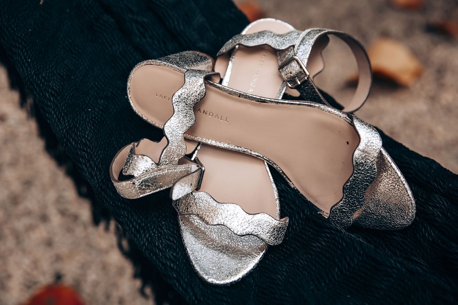 Close-up view of brown leather dress shoes against a dark textured background.