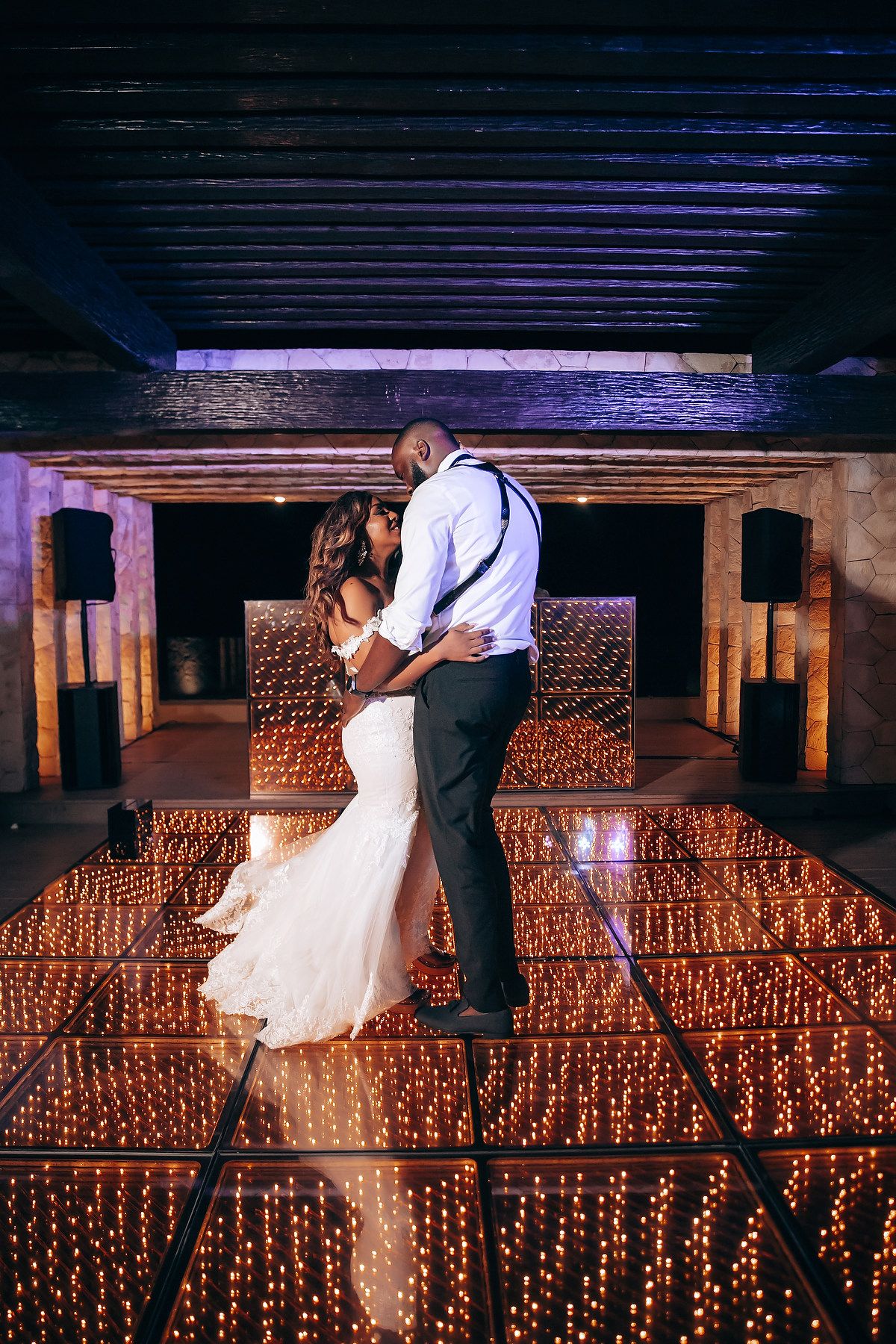 Romantic dance scene with couple illuminated by warm string lights in an intimate venue setting.