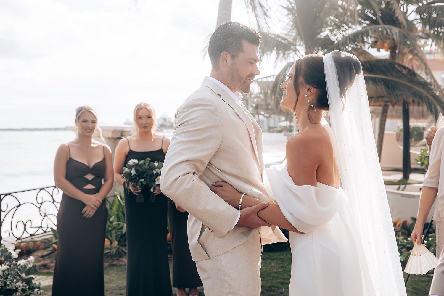 A romantic beach wedding ceremony and celebration with couples dancing and embracing by the ocean.