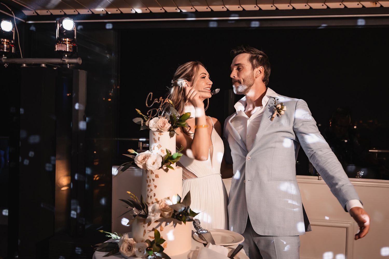 Wedding celebration on dance floor with dramatic lighting and festive atmosphere.