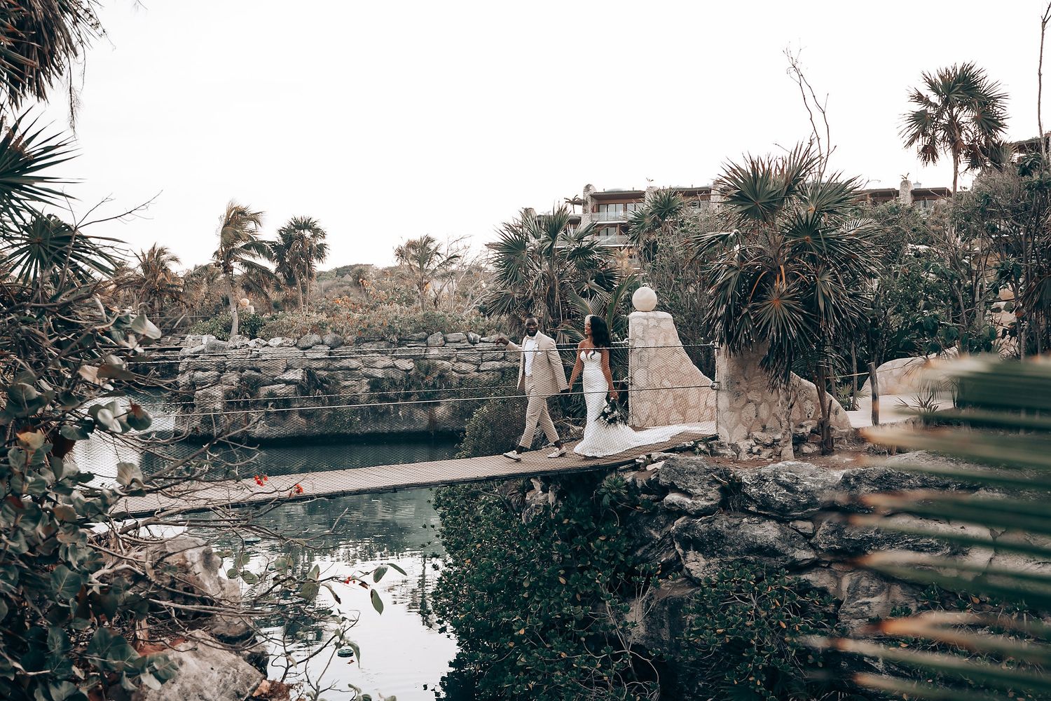 Scenic wedding venue overlooking tropical waters with stone pathways and palm trees.
