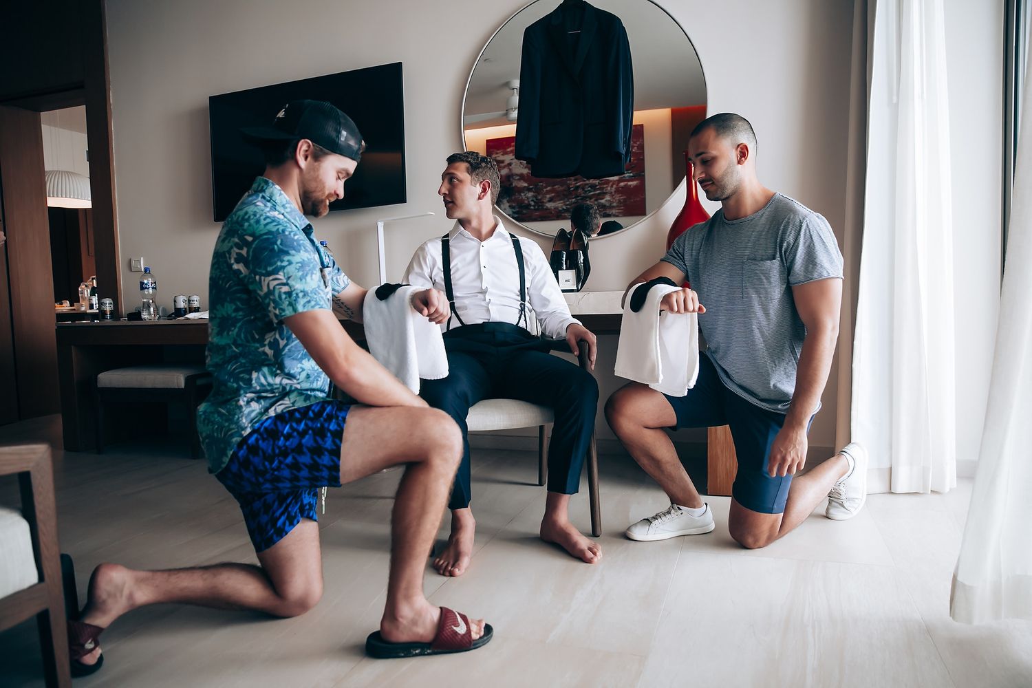 People relaxing in a bright modern room with large windows.