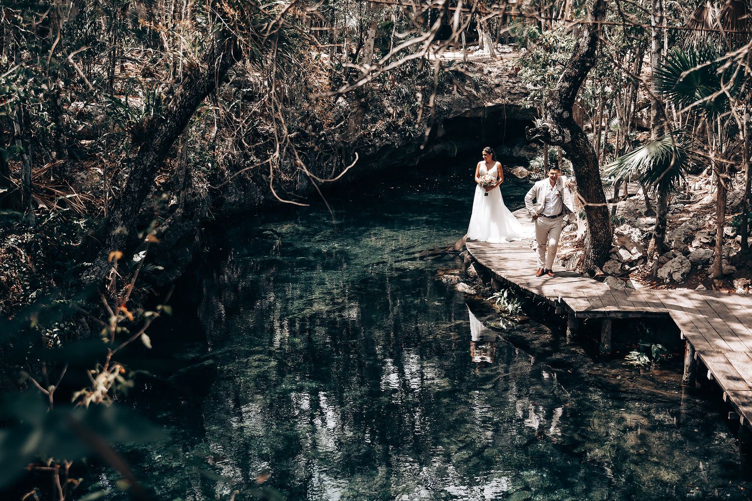 Forest wedding ceremony venue with wooden platforms extending over dark water.