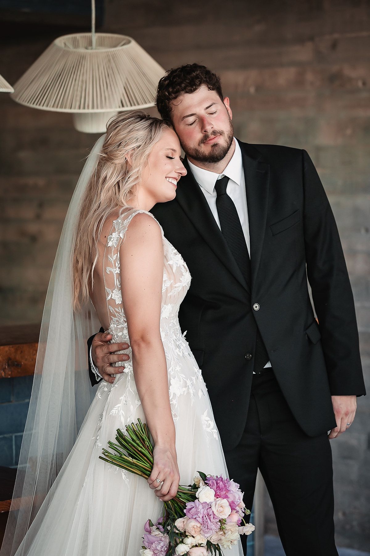 Romantic wedding portrait showing couple in formal attire with white dress and black suit.