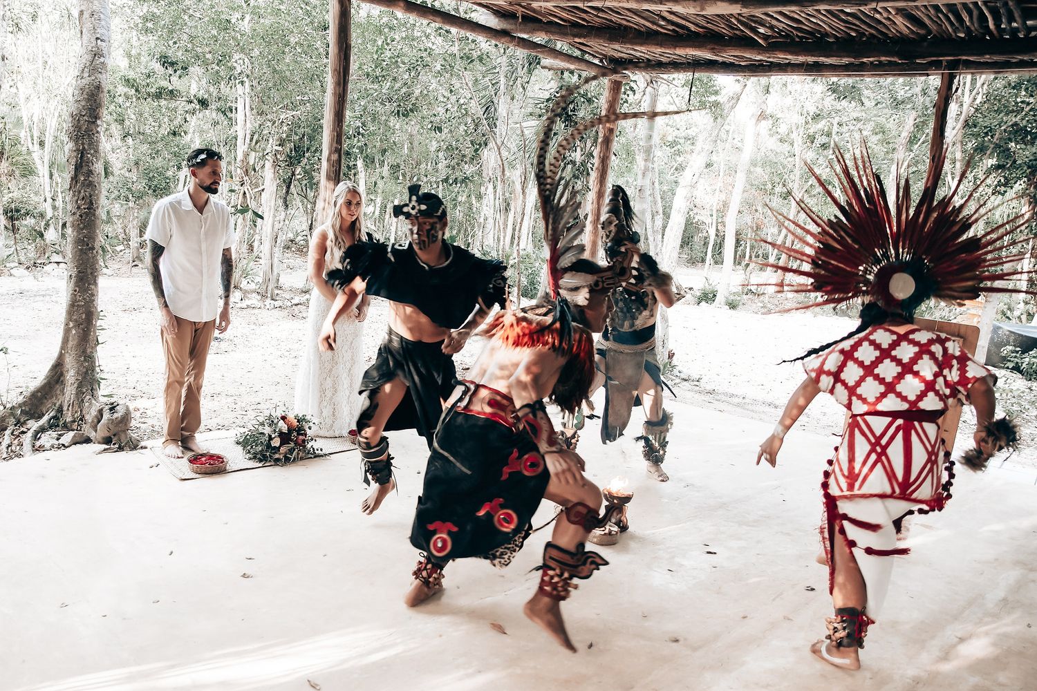 Indigenous performers in traditional Mayan costumes dance during ceremonial celebration.