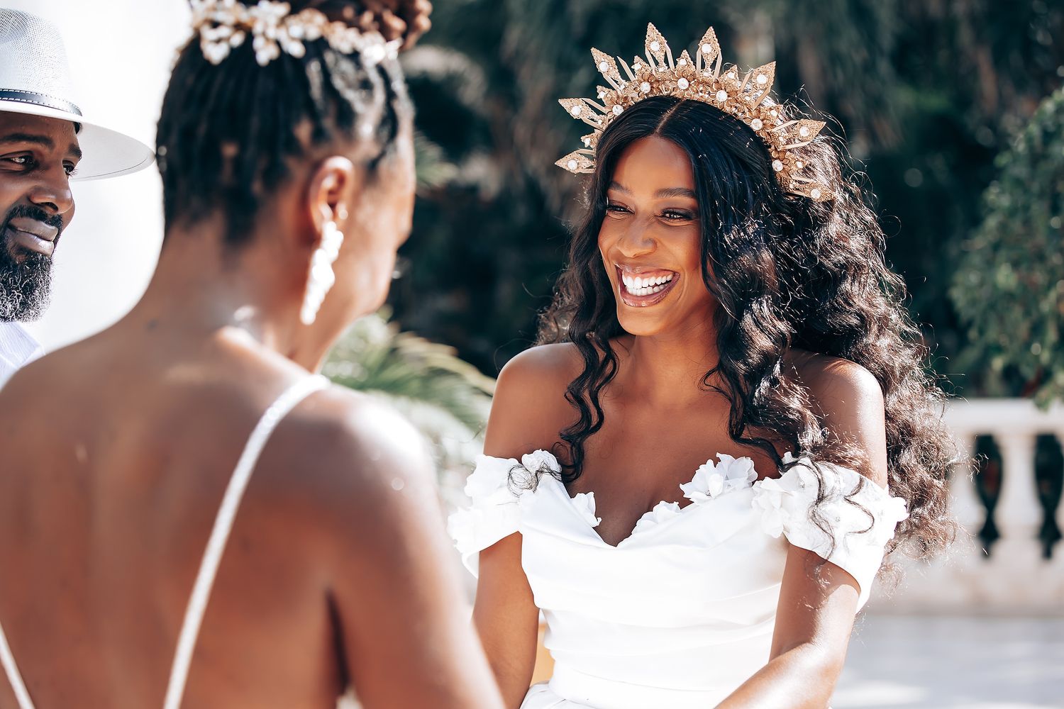 A wedding celebration with white dresses and floral decorations at a tropical venue.