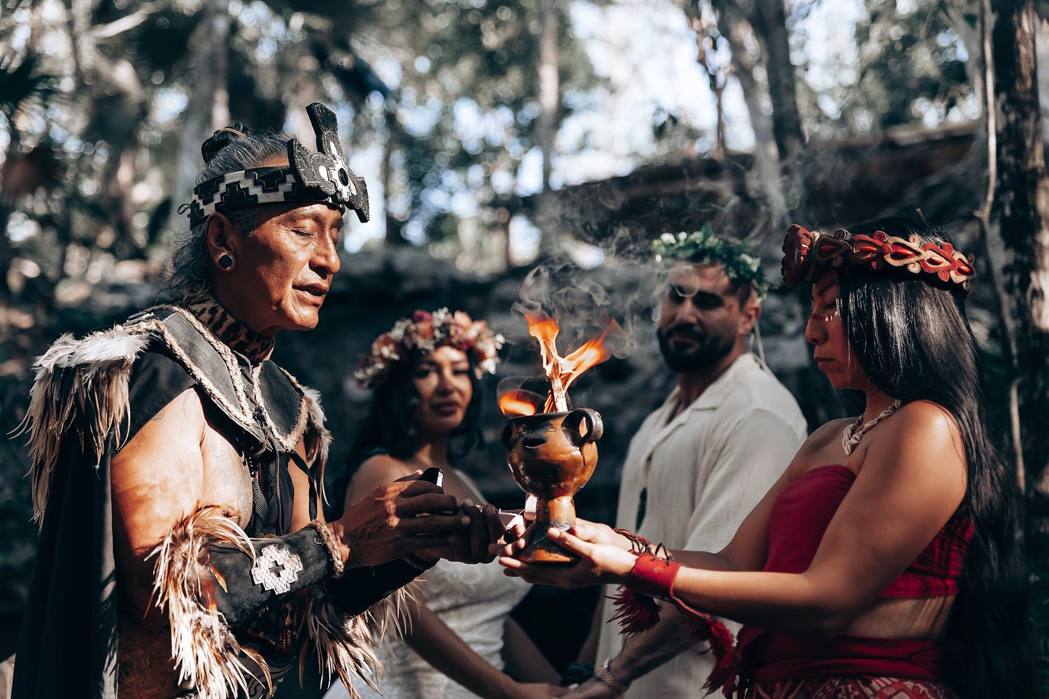 Wedding guests dance and celebrate together during an outdoor reception in a forest setting.
