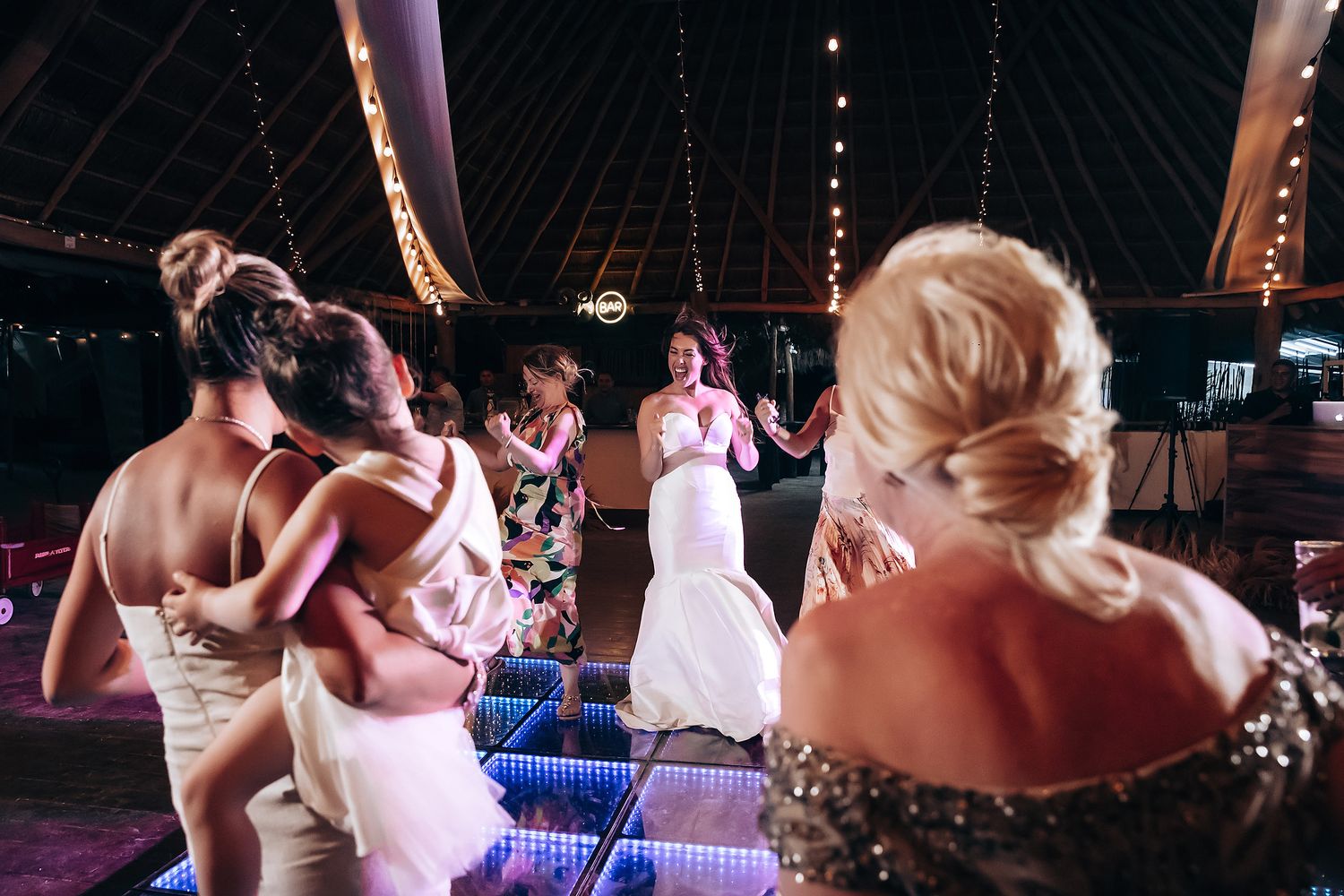 Couples dancing together on a dimly lit dance floor during what appears to be a wedding reception celebration.