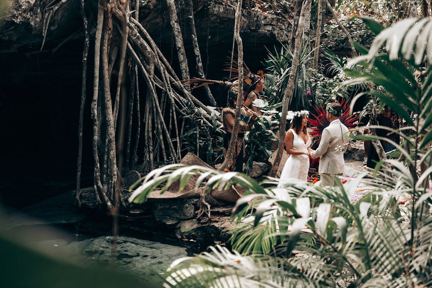 Wedding celebration in a tropical garden with palm trees and traditional ceremonial elements.