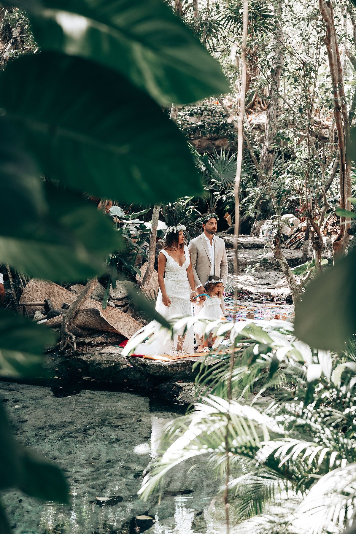 Intimate ceremony in tropical forest setting with traditional elements and natural lighting.
