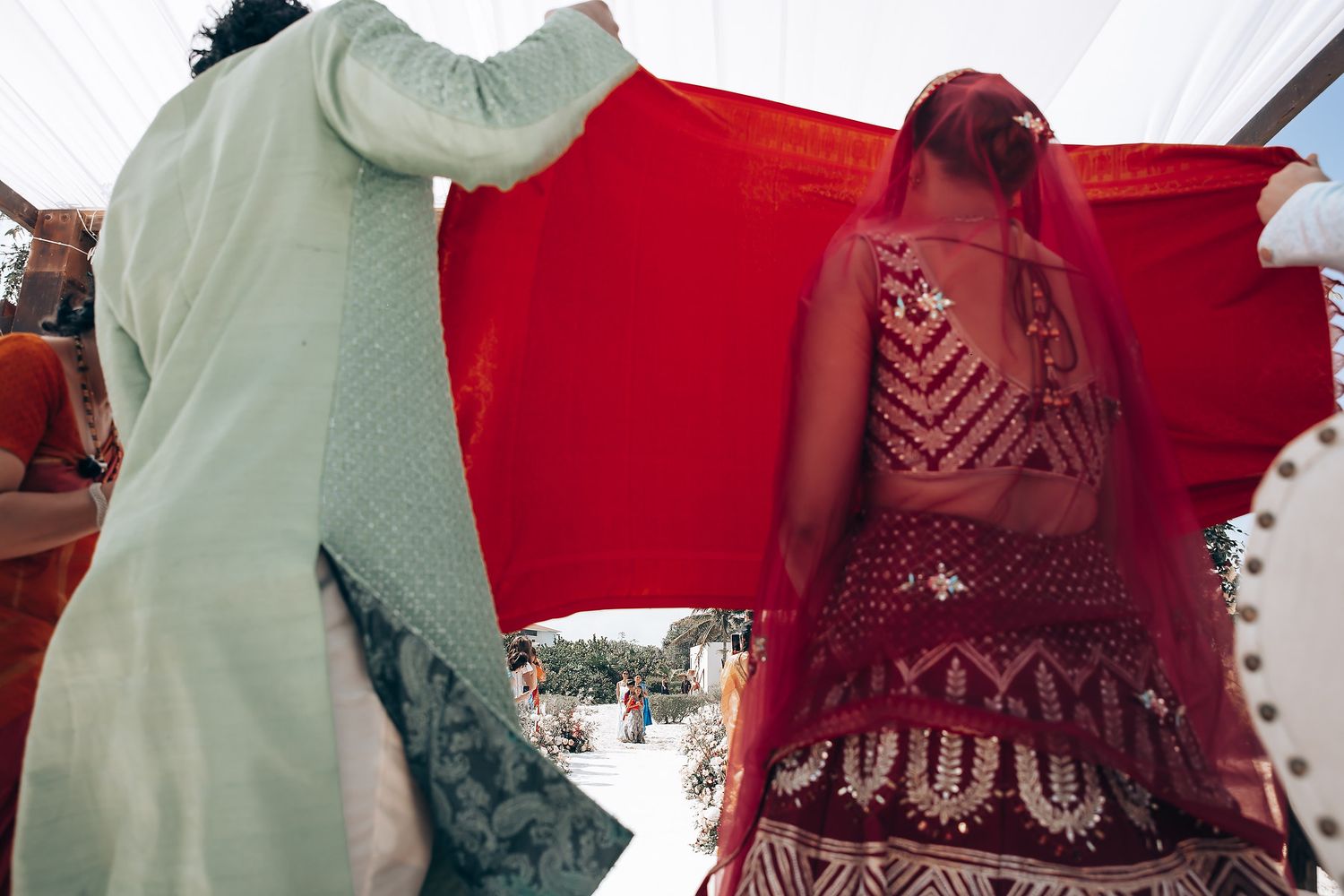 Traditional red and white Indian wedding attire displayed against a bright background.