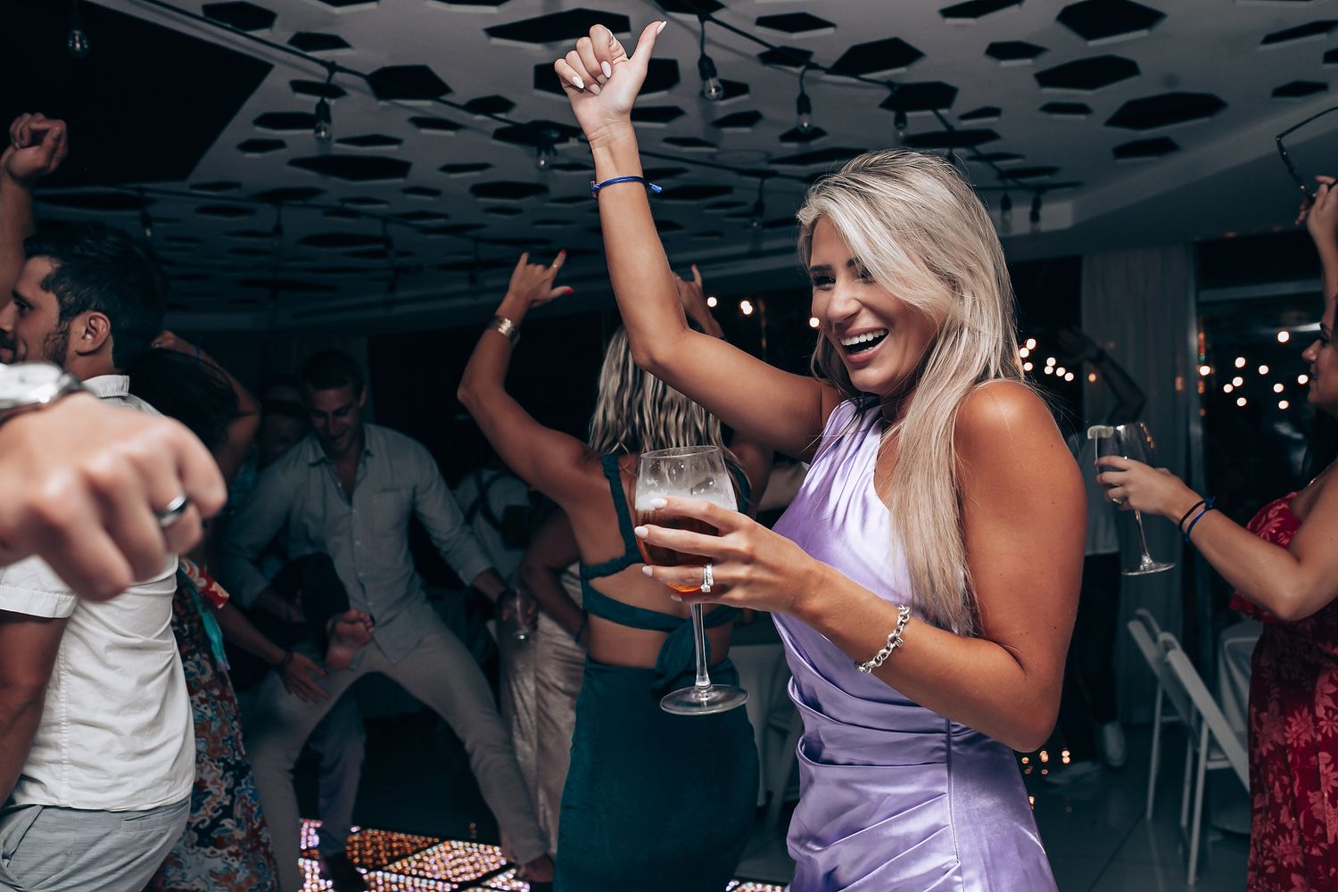 Wedding guests dancing and celebrating under unique spotted ceiling design.