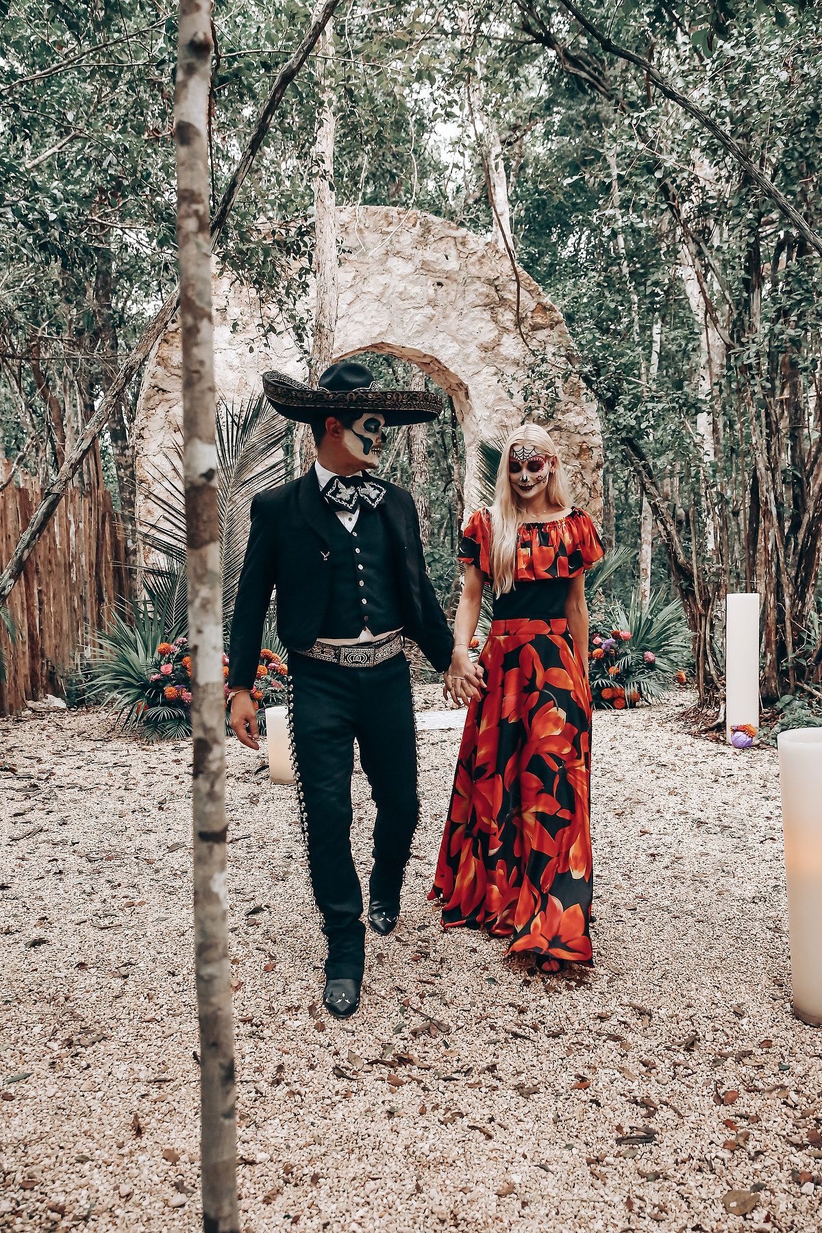 Atmospheric woodland path with couple in vintage-inspired Halloween costumes walking through trees.
