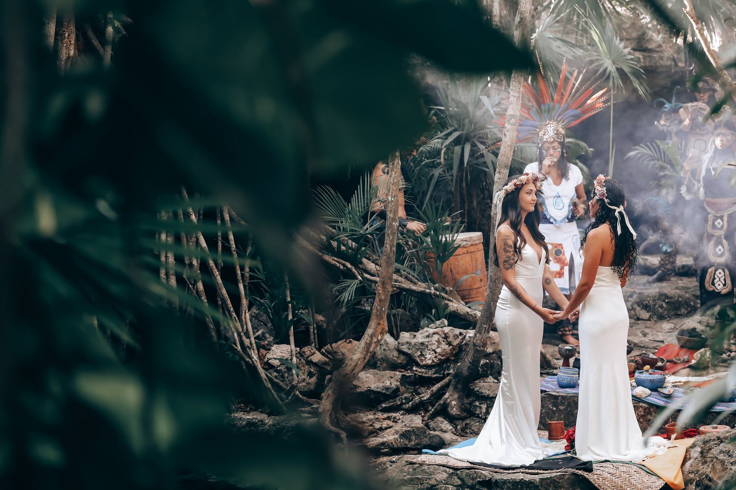 Two figures in white dresses standing among trees in a dreamy forest setting.