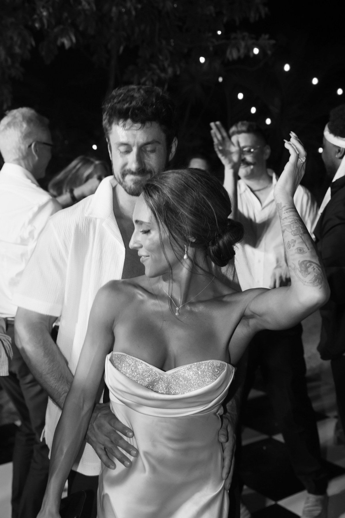 Bride and groom share a romantic dance at their outdoor evening wedding reception.