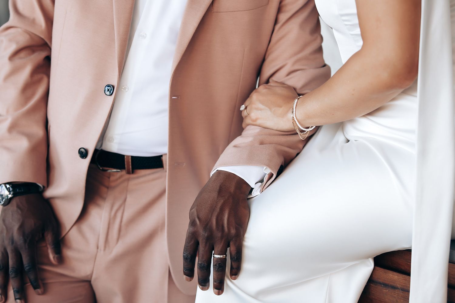 Close-up fashion detail shots of a tan suit jacket paired with white pants and accessories.