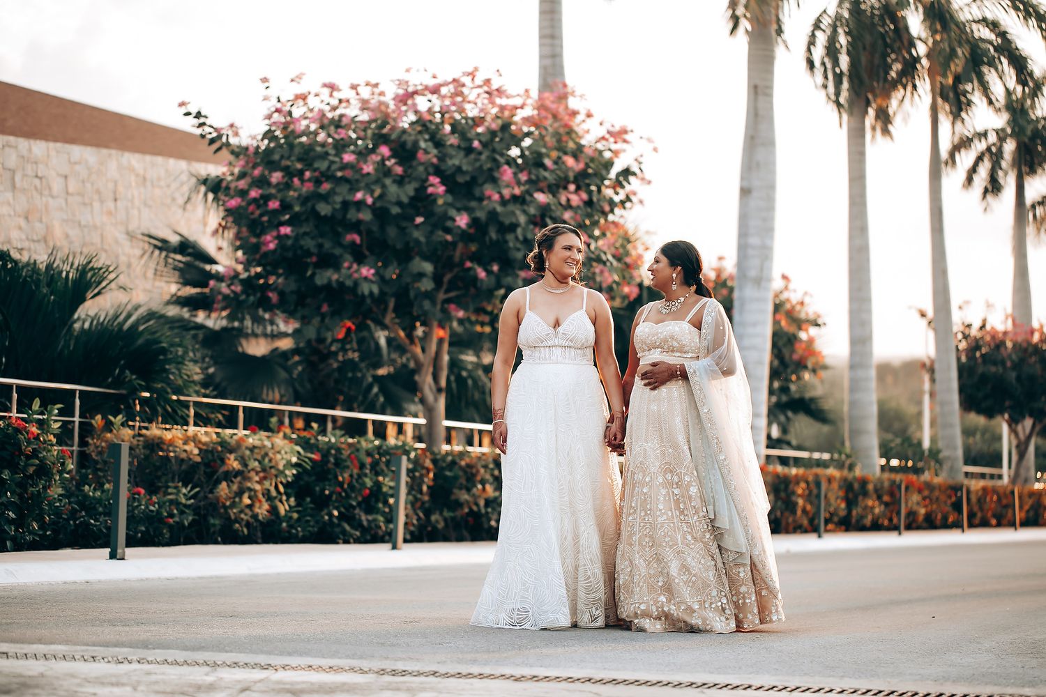 Elegant outdoor wedding venue decorated with palm trees and tropical flowers.
