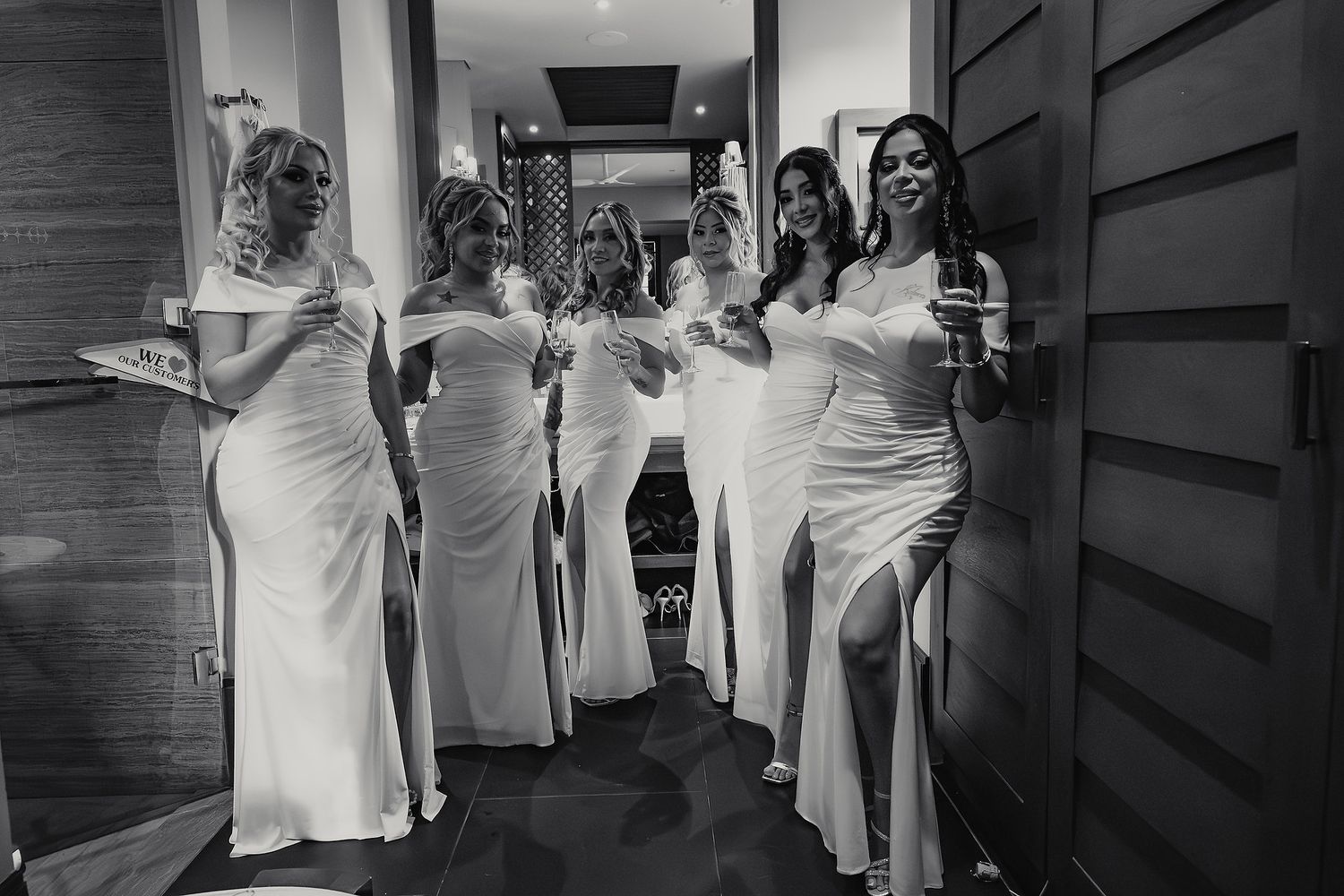 Black and white photos showing a group of people in white dresses walking together in a hallway.
