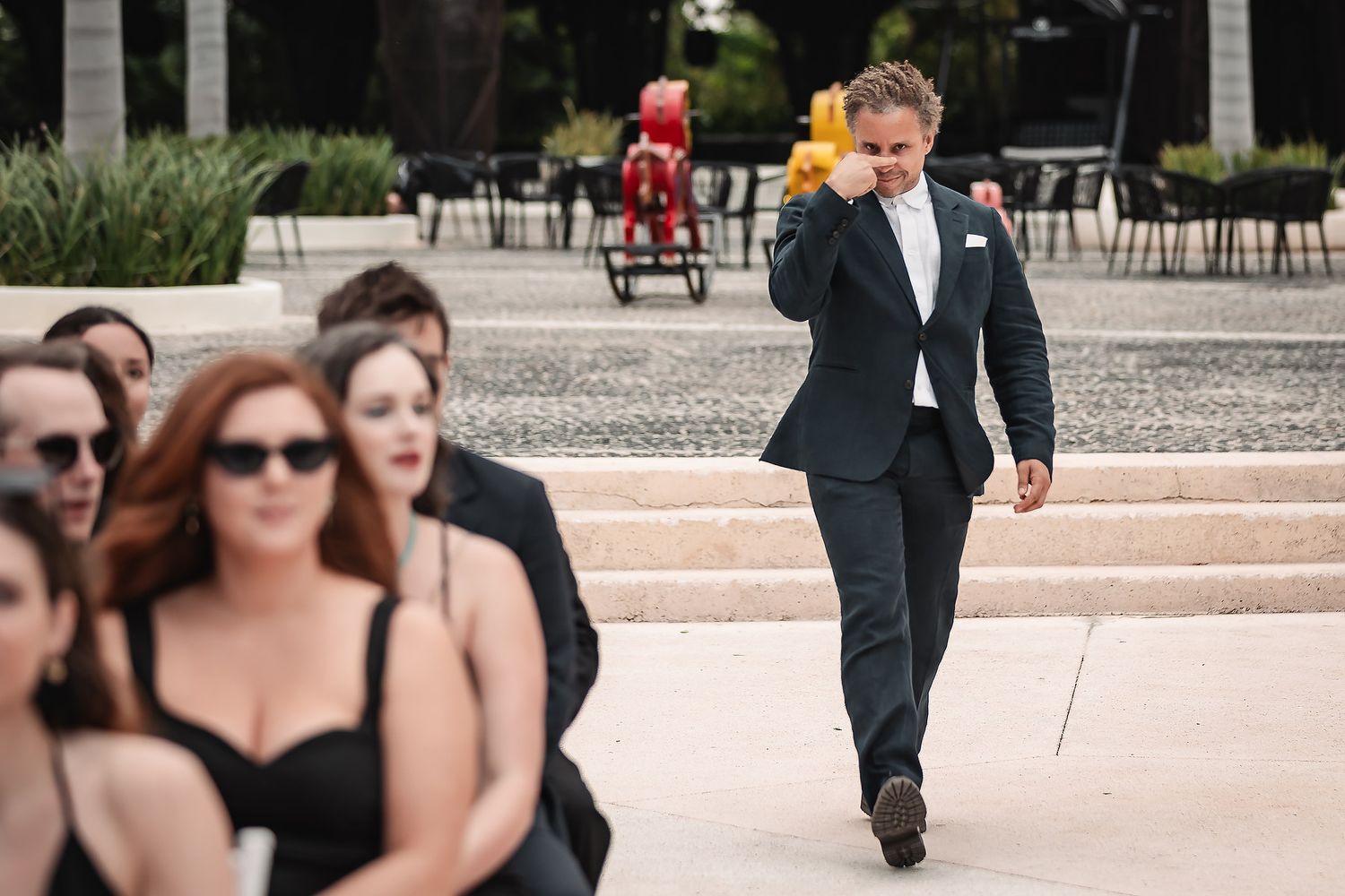 Wedding party members walking up outdoor stone steps at formal venue.