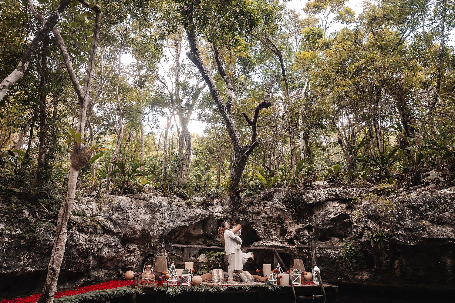 Sunlit forest setting with decorated platform by natural limestone pool.