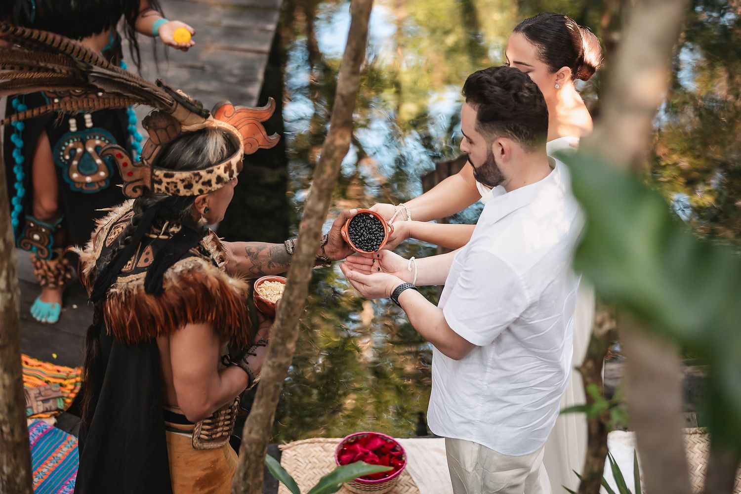 Traditional Mayan wedding ritual involving sharing ceremonial drink in natural outdoor setting.