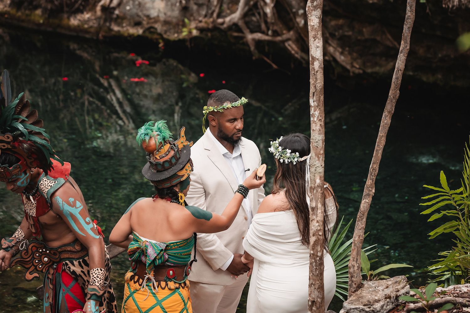 Cultural celebration with traditional dress and decorations at scenic jungle cenote.
