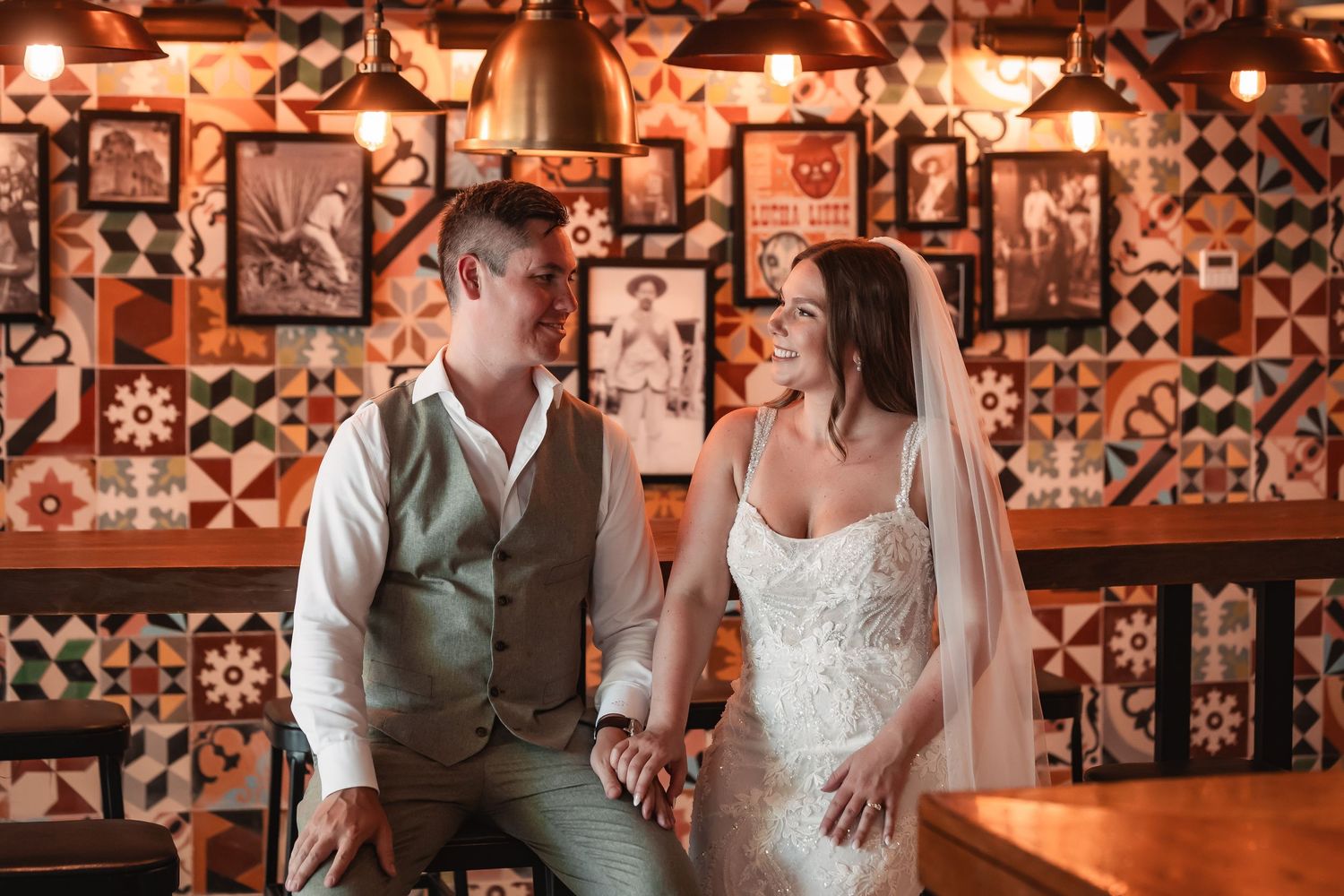 Rustic indoor wedding reception venue with decorative patterned walls and warm lighting creating an intimate atmosphere.