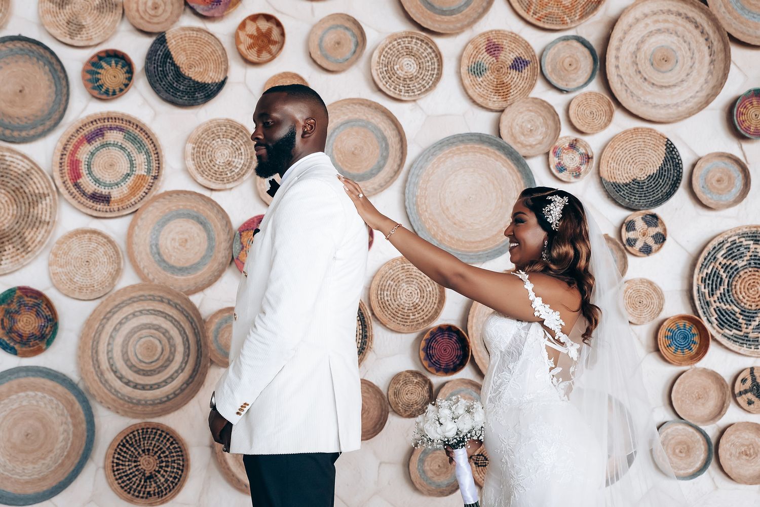 Decorative woven baskets and plates arranged artistically on a neutral wall as bohemian wedding decor.