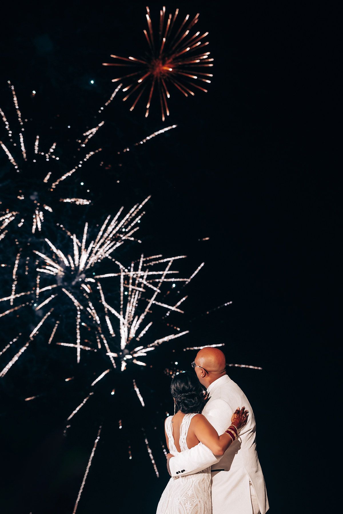 Fireworks display illuminating the night sky during a wedding celebration.