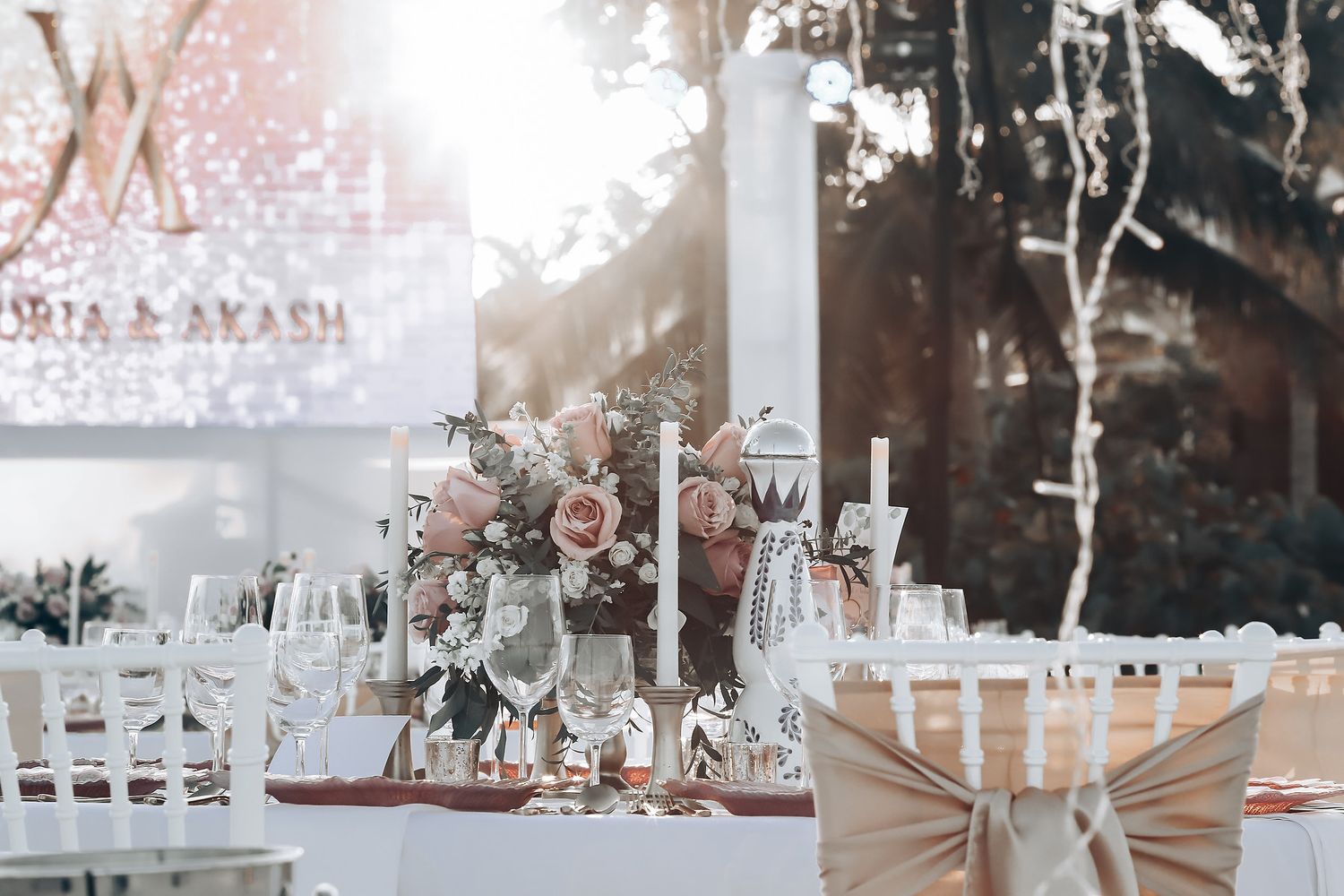 Elegant wedding reception setup with white table settings and natural light streaming through windows.