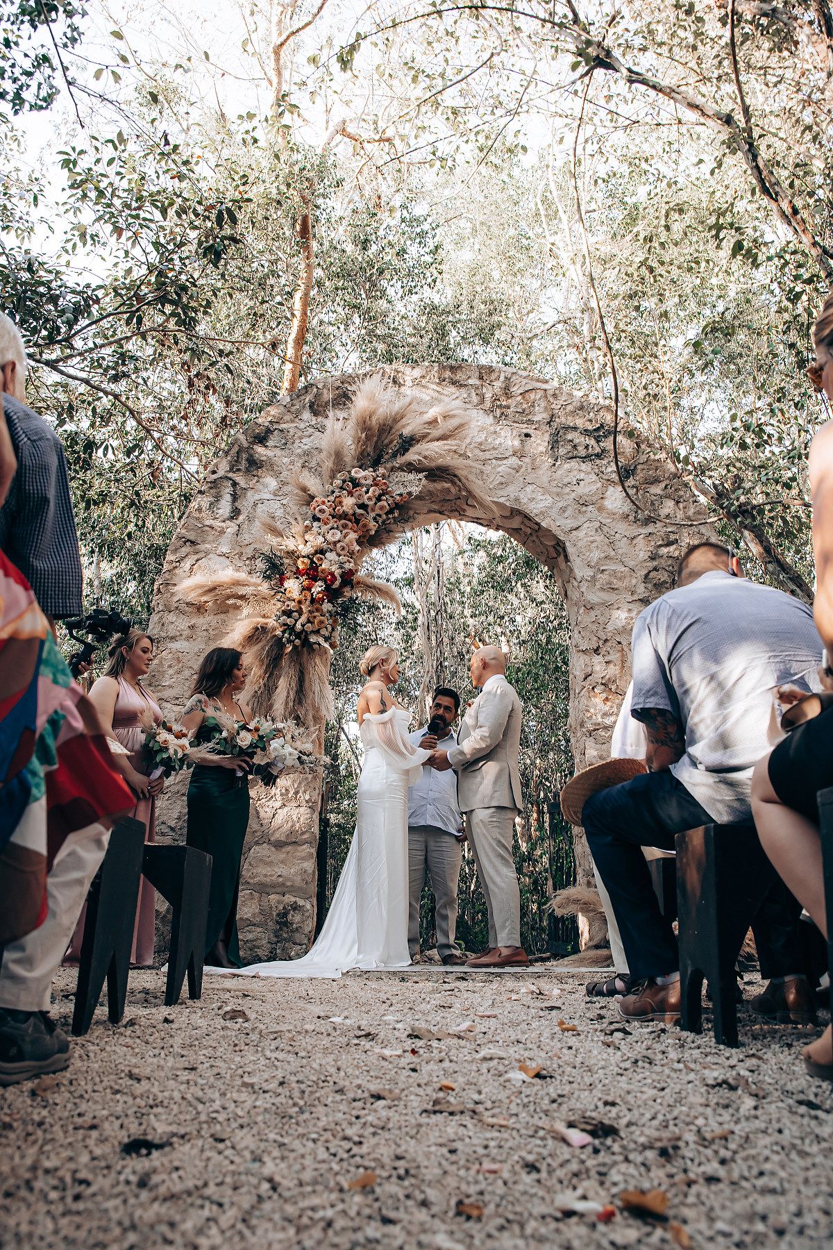 Wedding ceremony in a rustic outdoor setting surrounded by natural foliage.