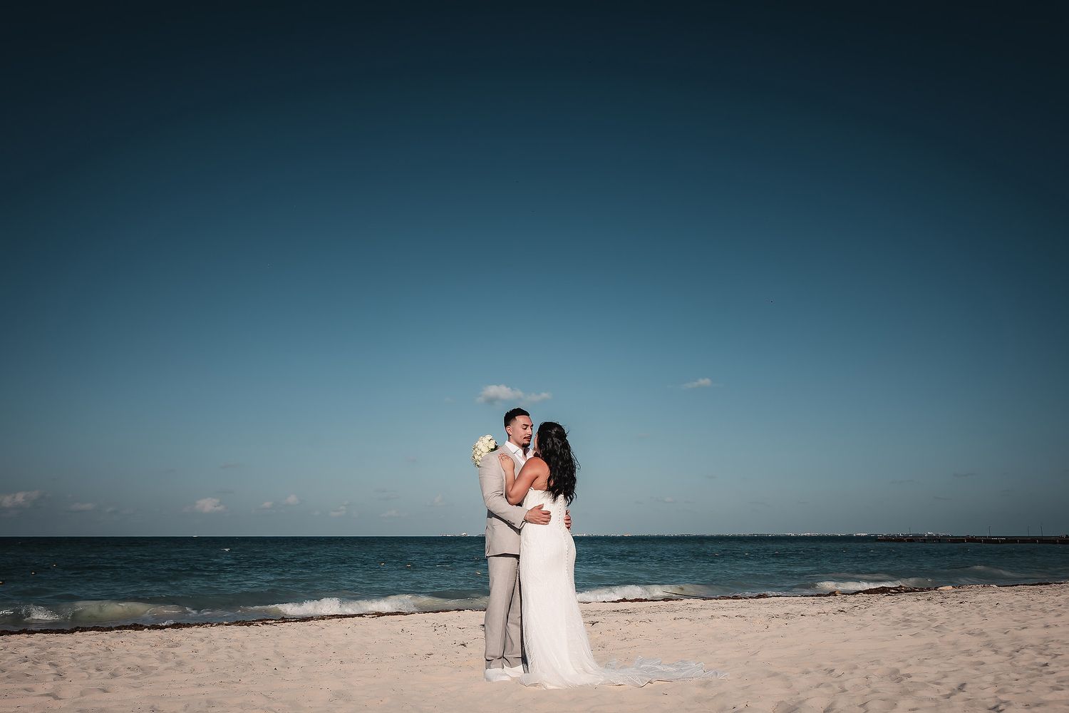 Beautiful beach wedding setting with couple against ocean backdrop.