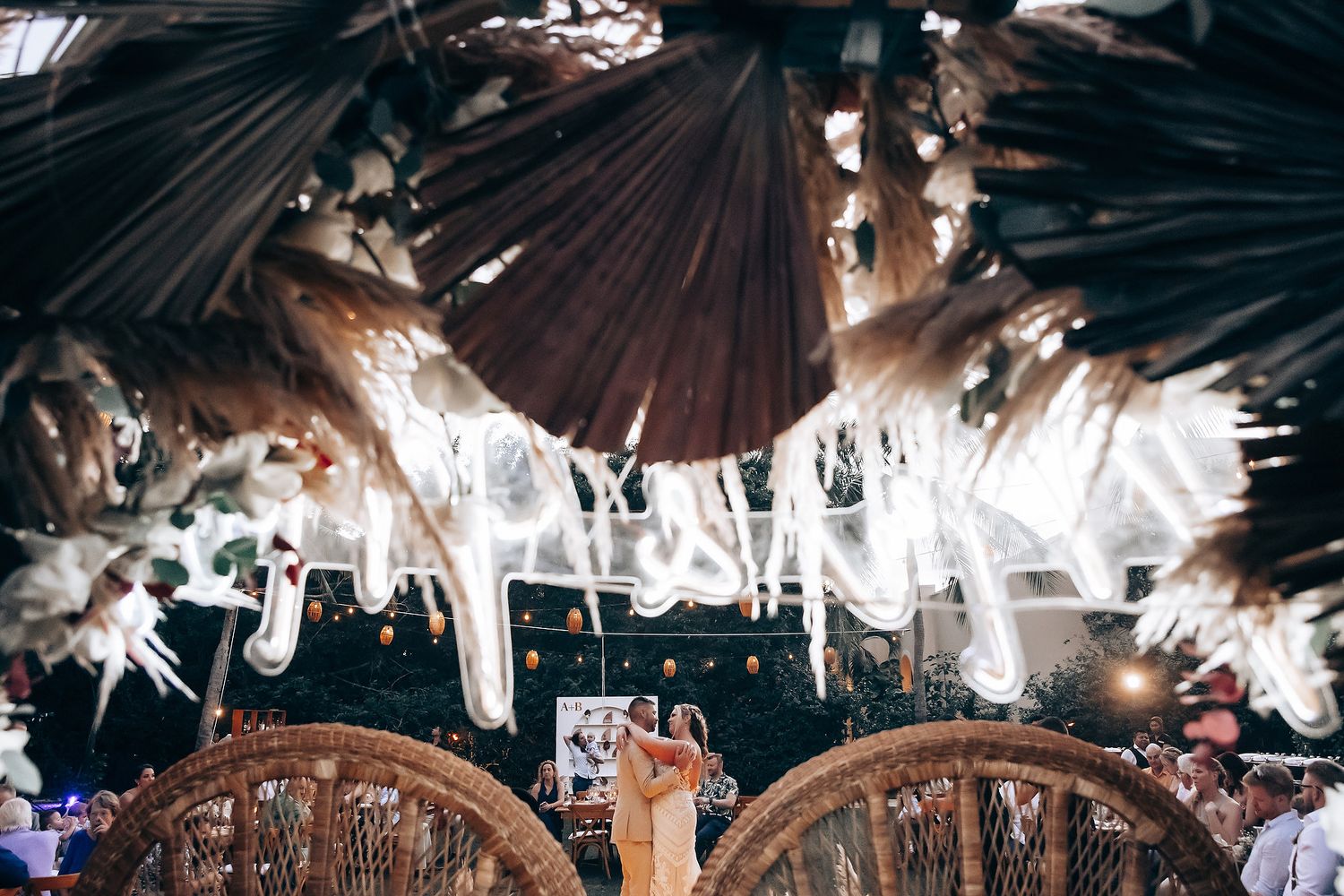 Wedding reception venue decorated with string lights and rustic wooden beams creating a warm ambiance.