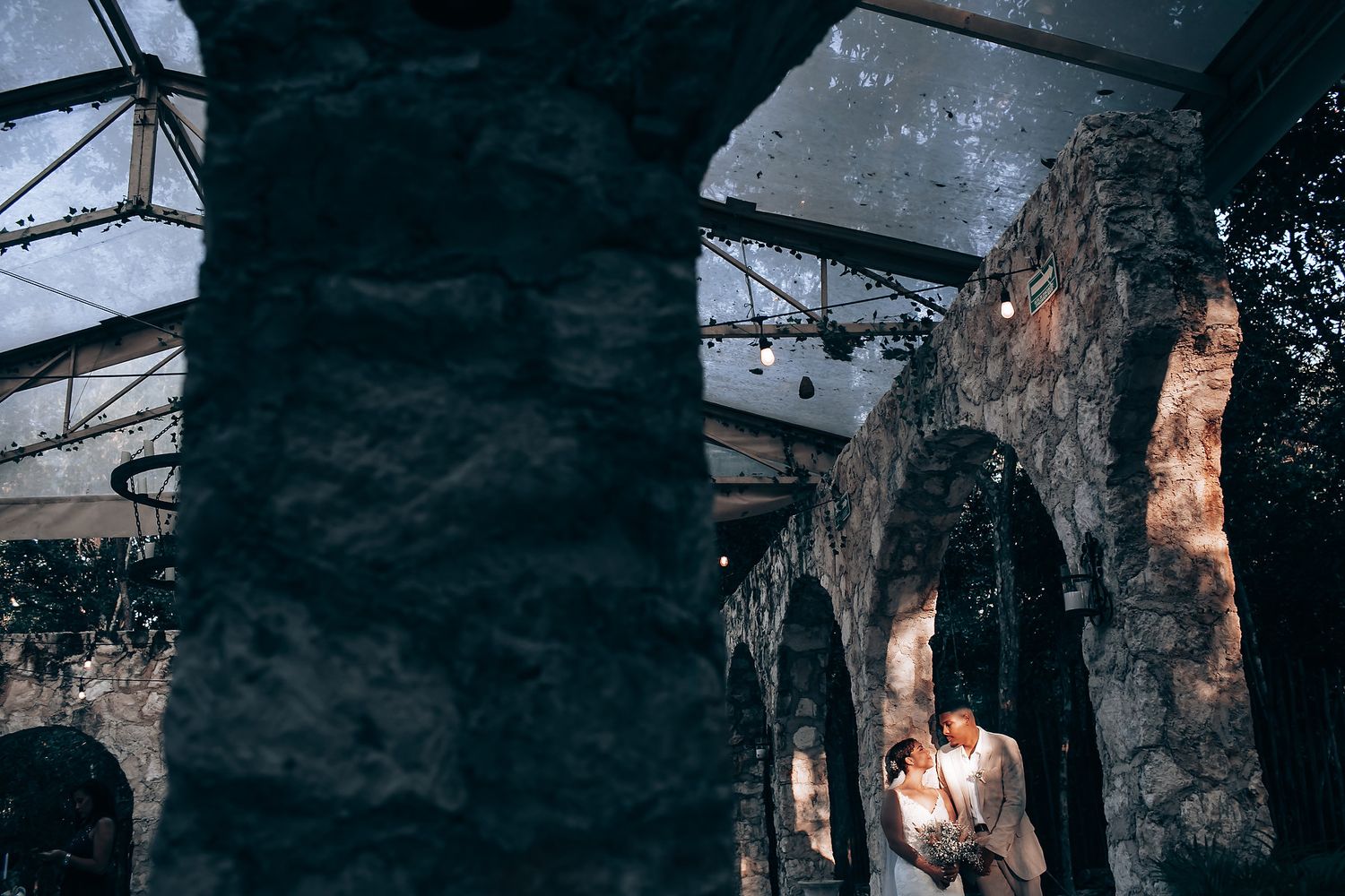Dark and moody wedding photography in an indoor venue with dramatic lighting.